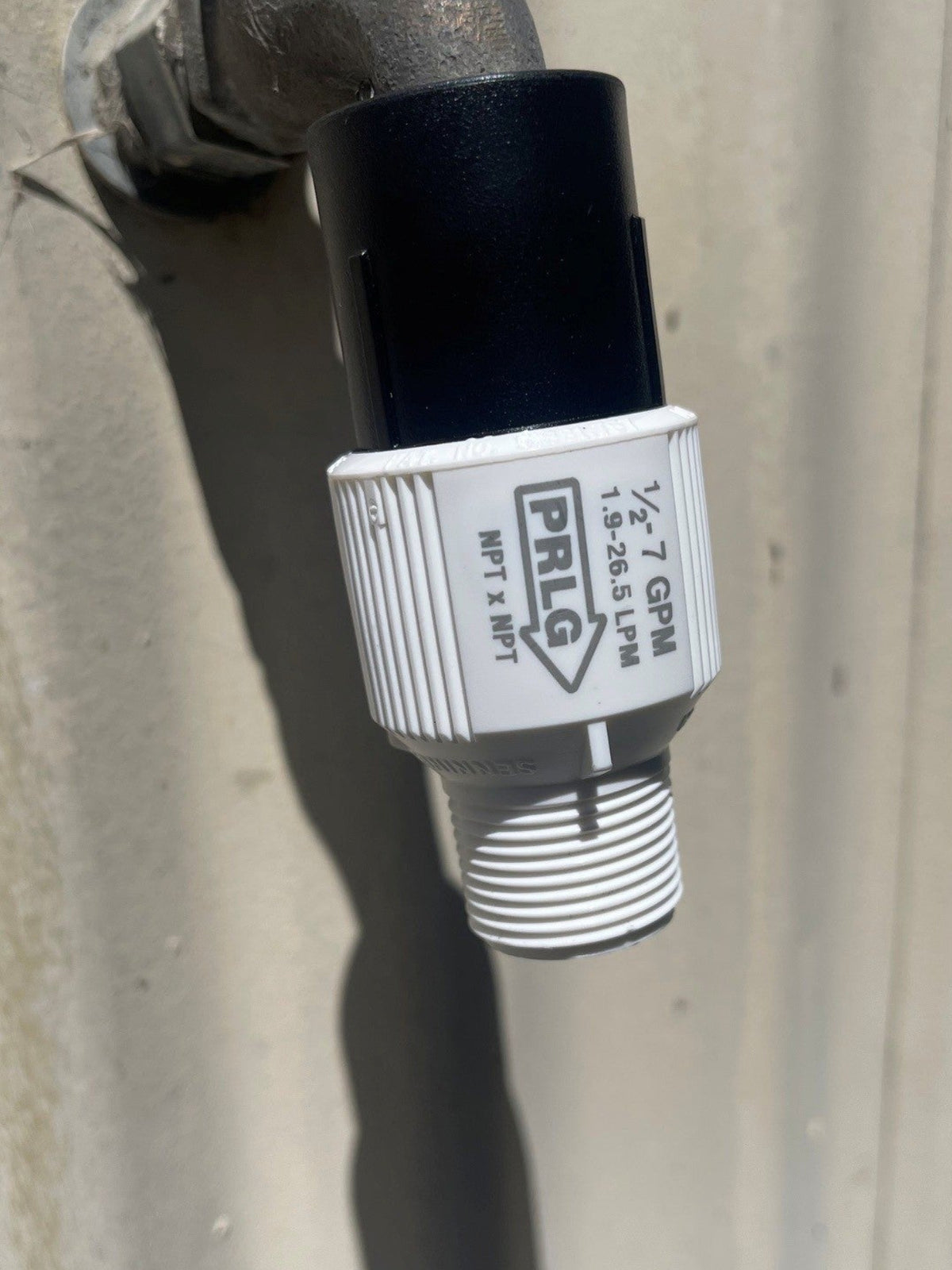 Senninger 25 PSI plastic irrigation pressure regulator thread installed on a garden tap